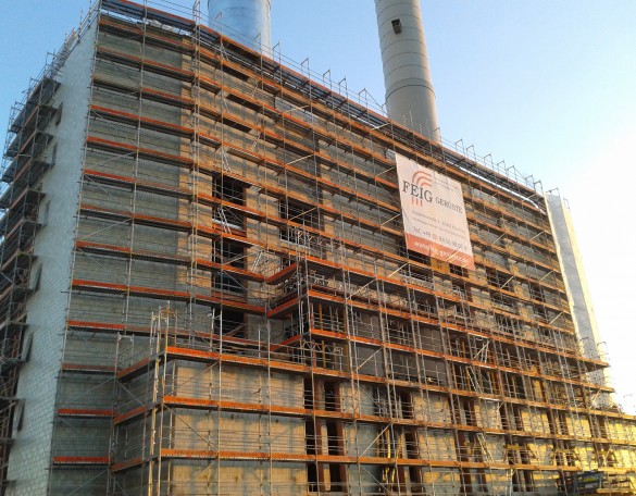 Geruestbau-Arbeiten am Olympiatower in Muenchen bei Sonnenaufgang.